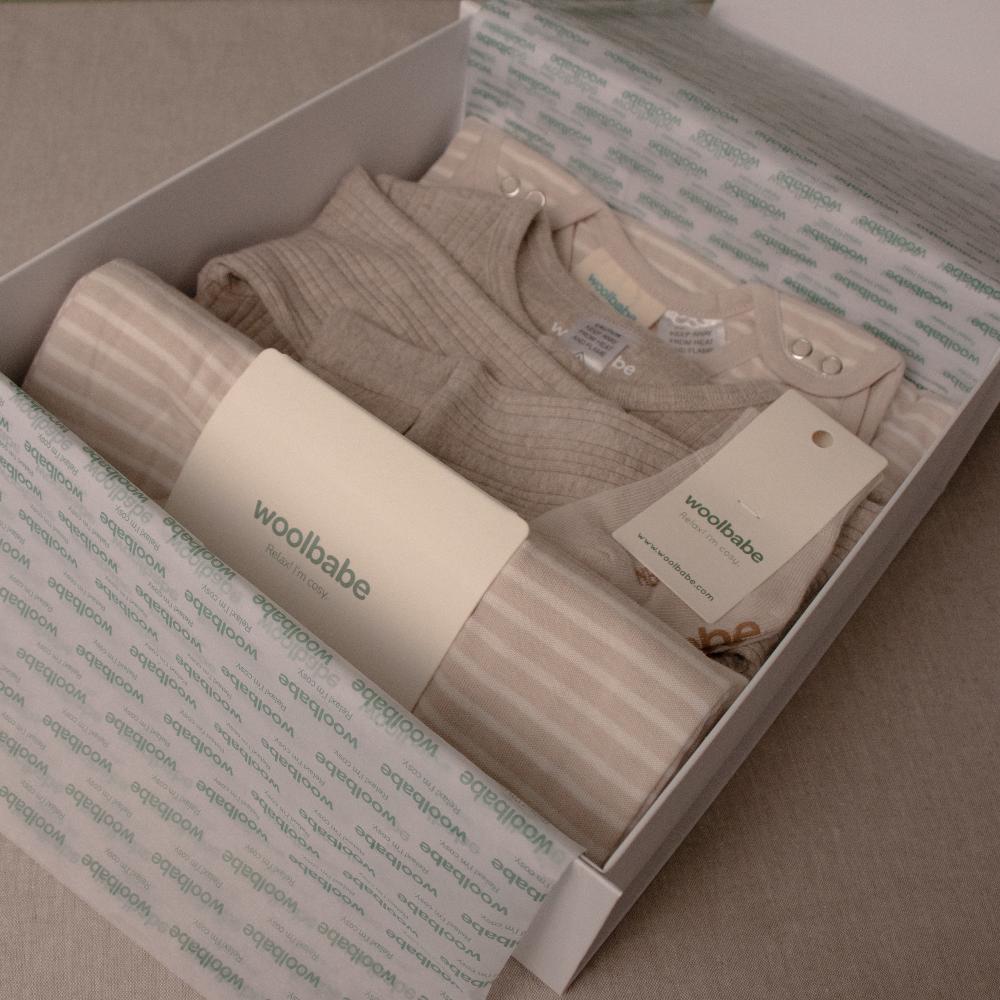 Woolbabie baby clothing set in a box with branded packaging.