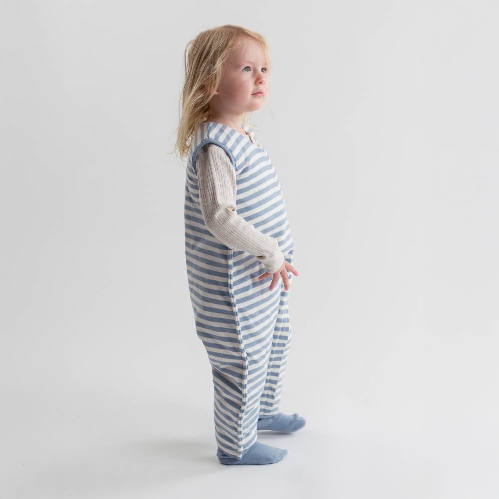 Child wearing a blue and white striped outfit on a plain background