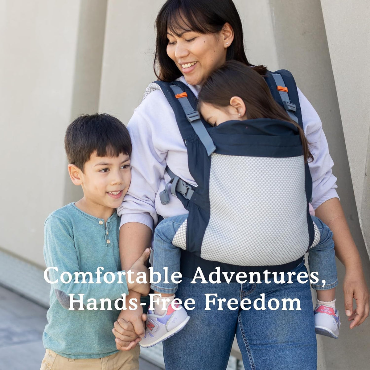 Woman using a baby carrier with two children, with text 'Comfortable Adventures, Hands-Free Freedom'.