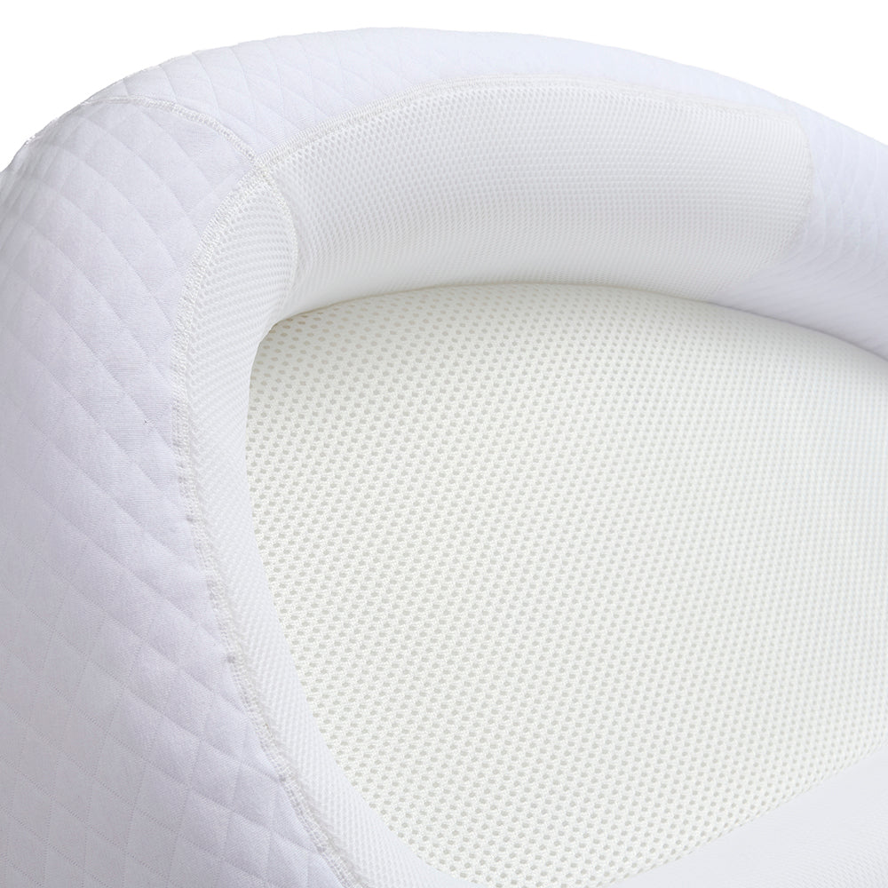Close-up of a white mesh breathable baby nest with textured surface and border