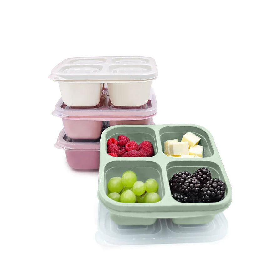 Pink and green compartmentalized meal prep container with fruits and a pink stacked container on a white background