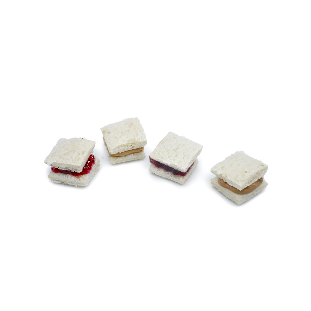 Four miniature sandwiches with different fillings on a white background