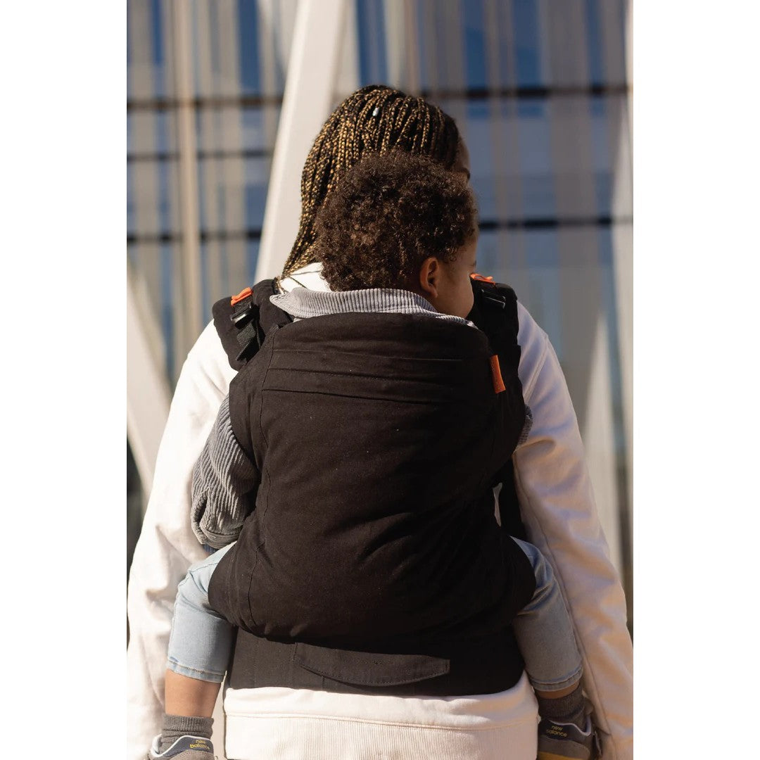 Toddler being worn on a woman's back in a Beco Toddler Carrier